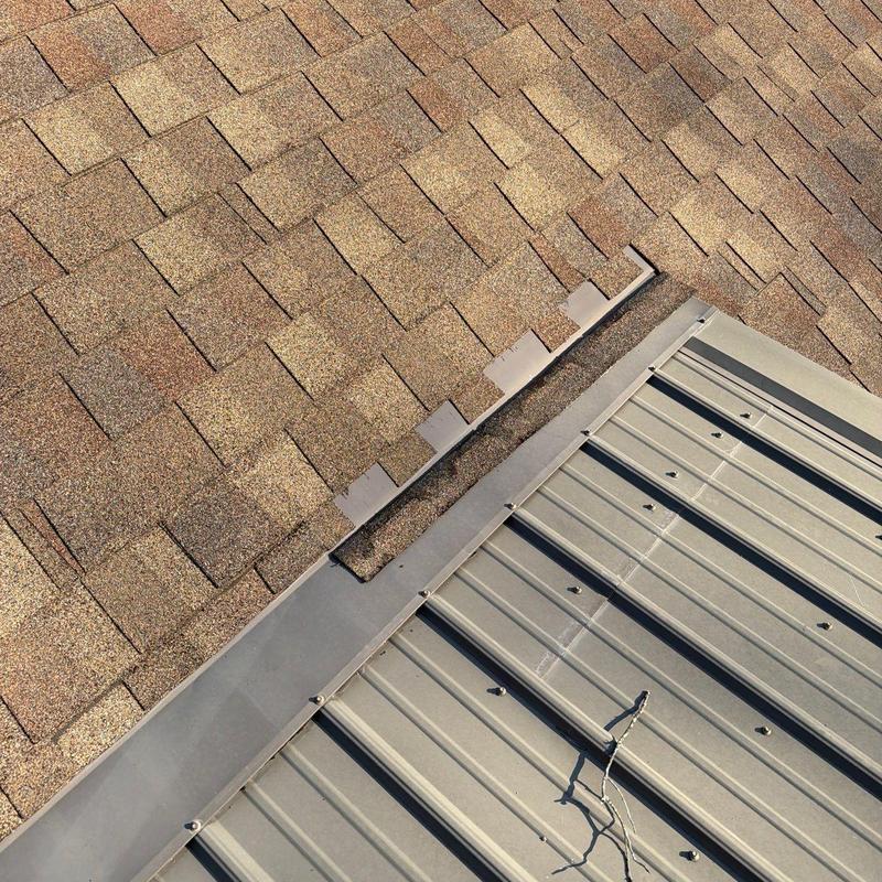 Roof shingles and metal roof intersection with flashing