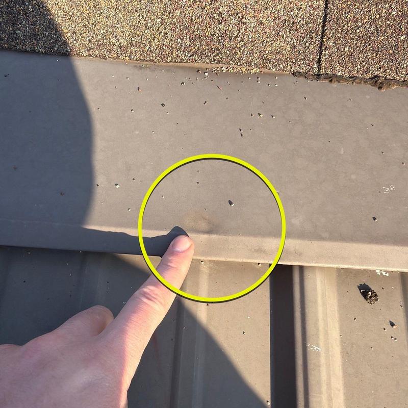 Metal roofing panel dent with finger for scale
