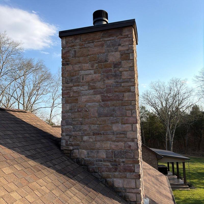Roof shingles and stone chimney with roof vent