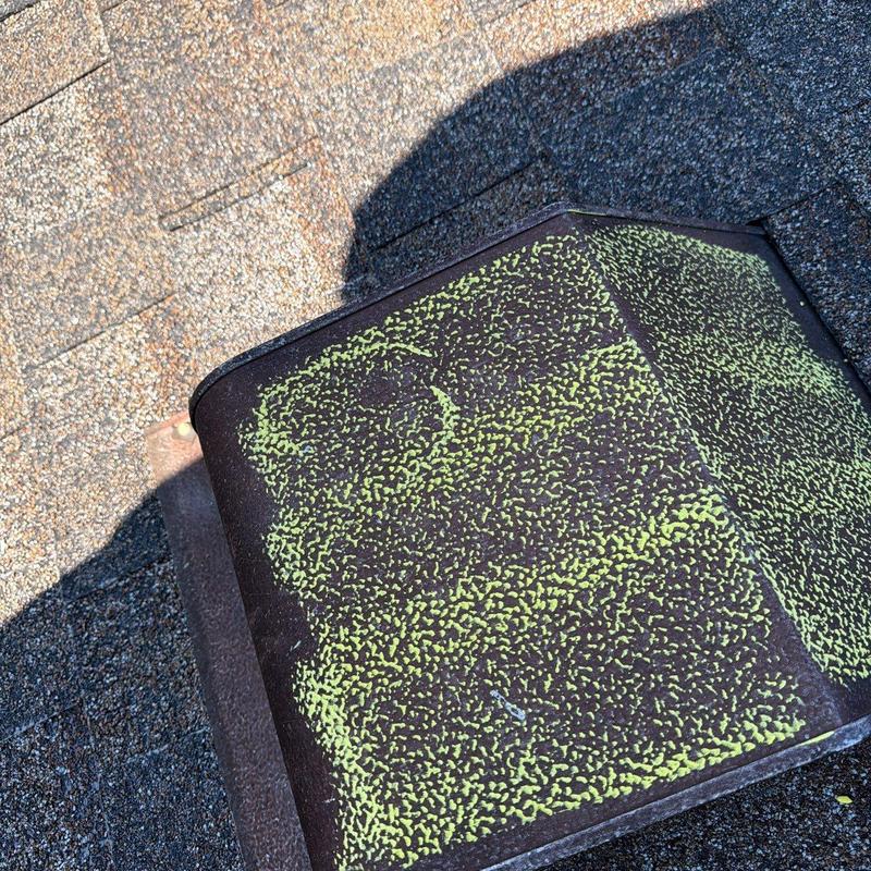 Roof vent with hail impact marks and granule loss