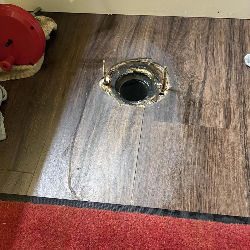 Toilet flange on wood floor with sealant residue Toilet flange on wood floor with sealant residue