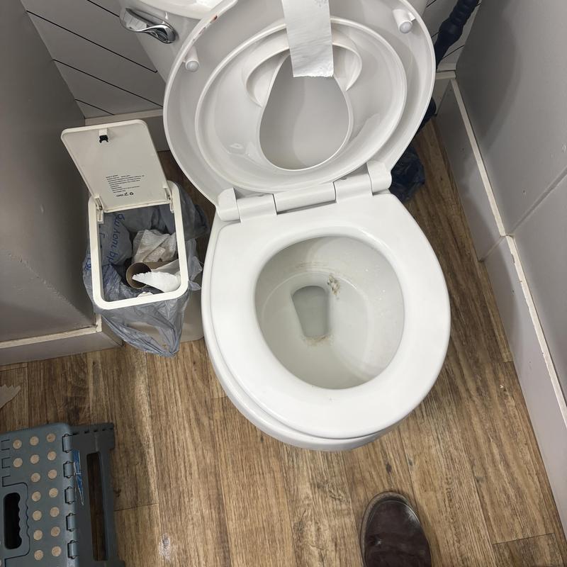 Childcare toilet bowl with open lid and paper roll
