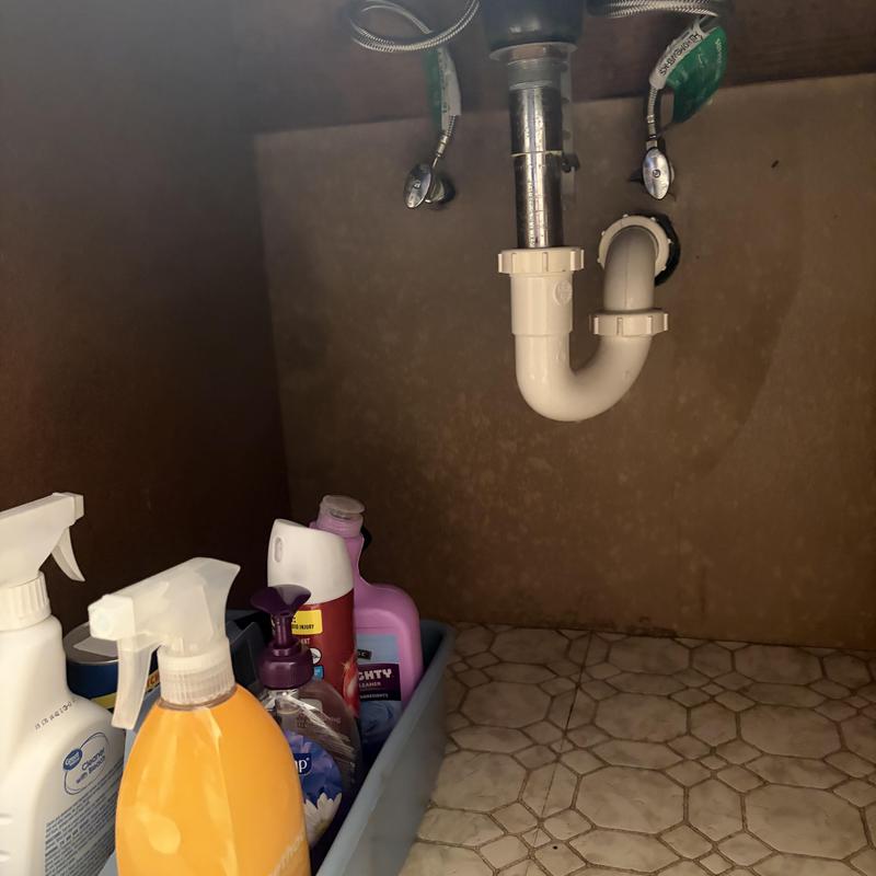 Kitchen sink waste piping with valves and cleaning supplies