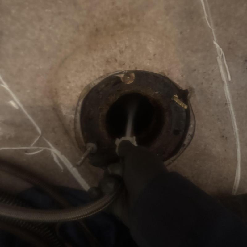 Toilet flange with plumbing snake clearing blockage