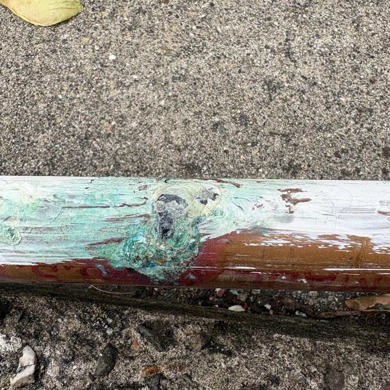 Copper water line with corrosion damage before repair