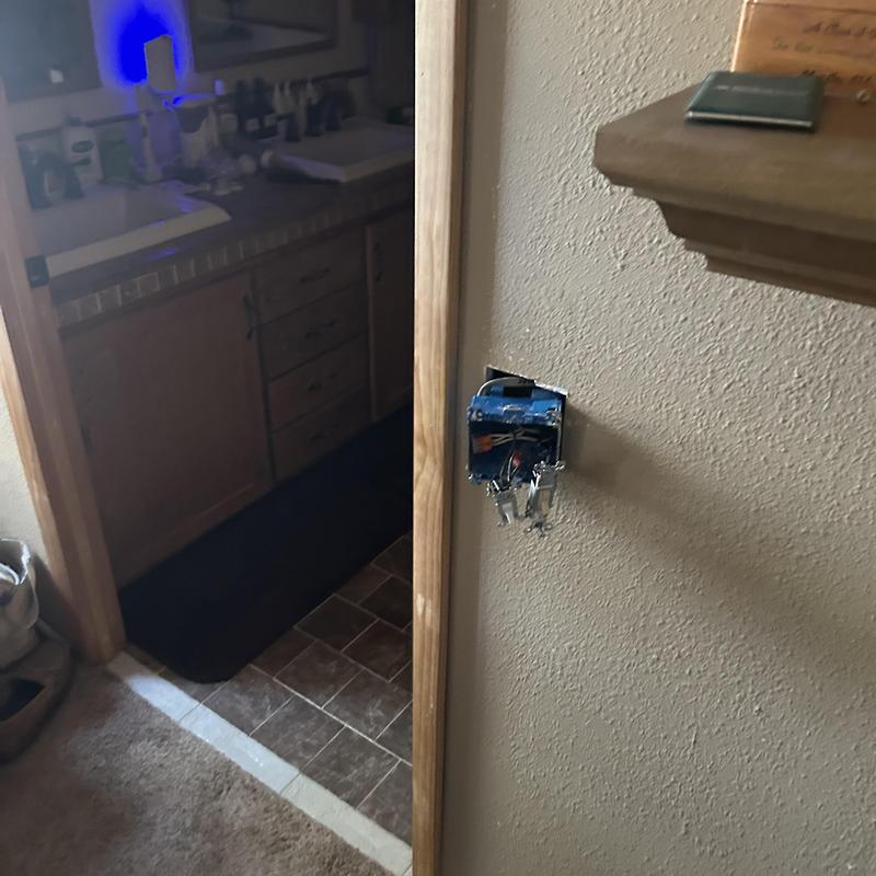 Electrical outlet box with exposed wiring in wall