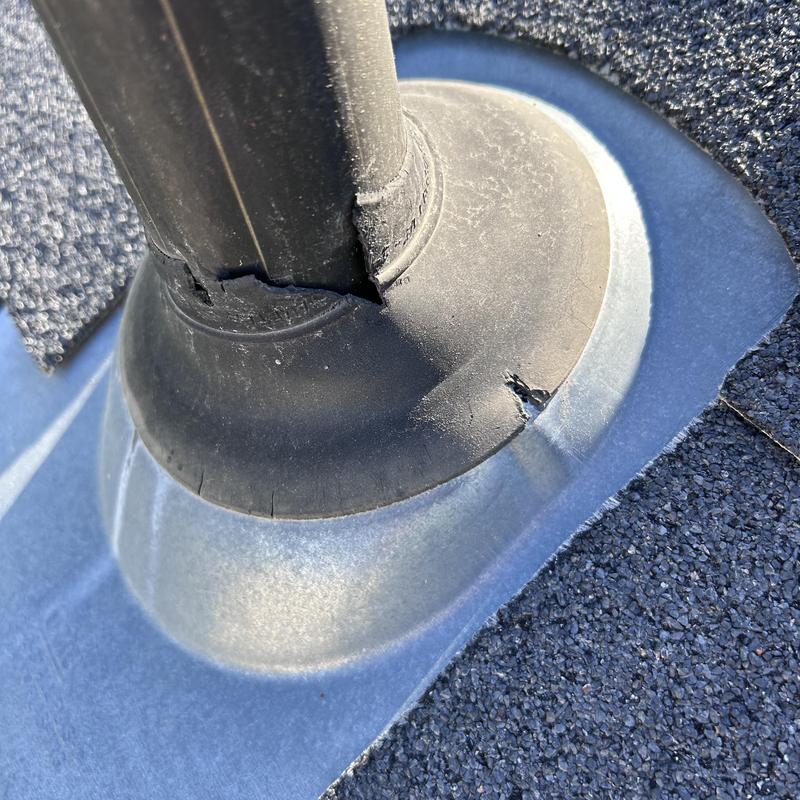 Pipe boot flashing on worn shingle roof with cracks Pipe boot flashing on worn shingle roof with cracks