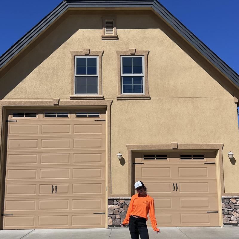 Garage door system with dual beige doors and stone trim Garage door system with dual beige doors and stone trim