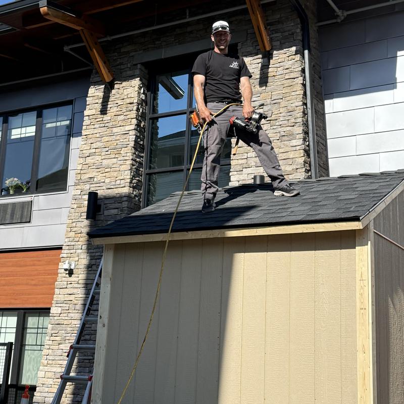 IKO Cambridge shingle roof on shed with roofer standing IKO Cambridge shingle roof on shed with roofer standing