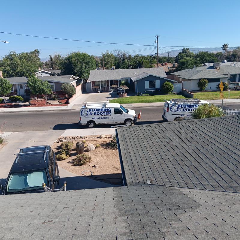 Swamp cooler repair with plumbing vans in residential area