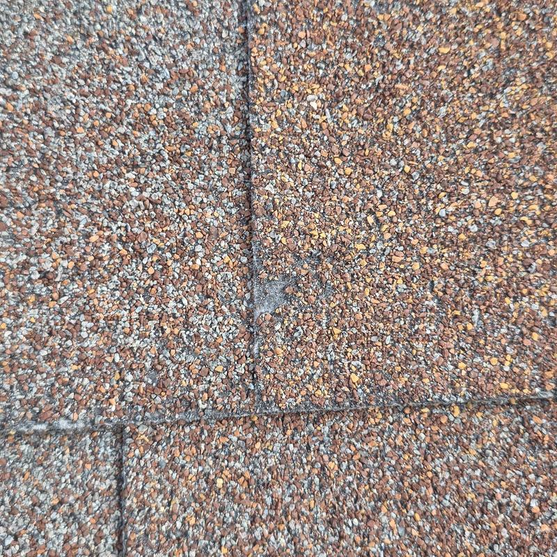 Asphalt shingle roofing with hail damage close-up