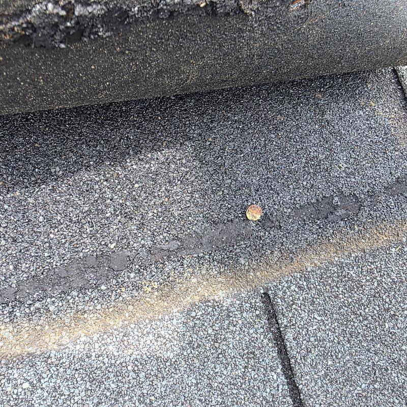 Three tab roof with exposed nail and sealed area