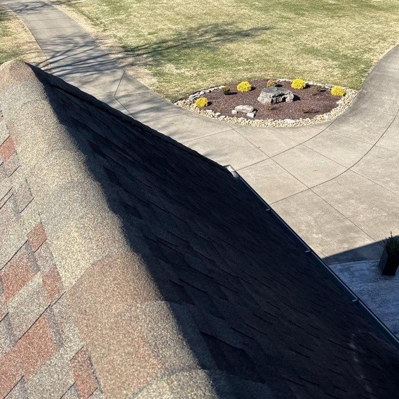 Asphalt shingle roof ridge with visible granule wear