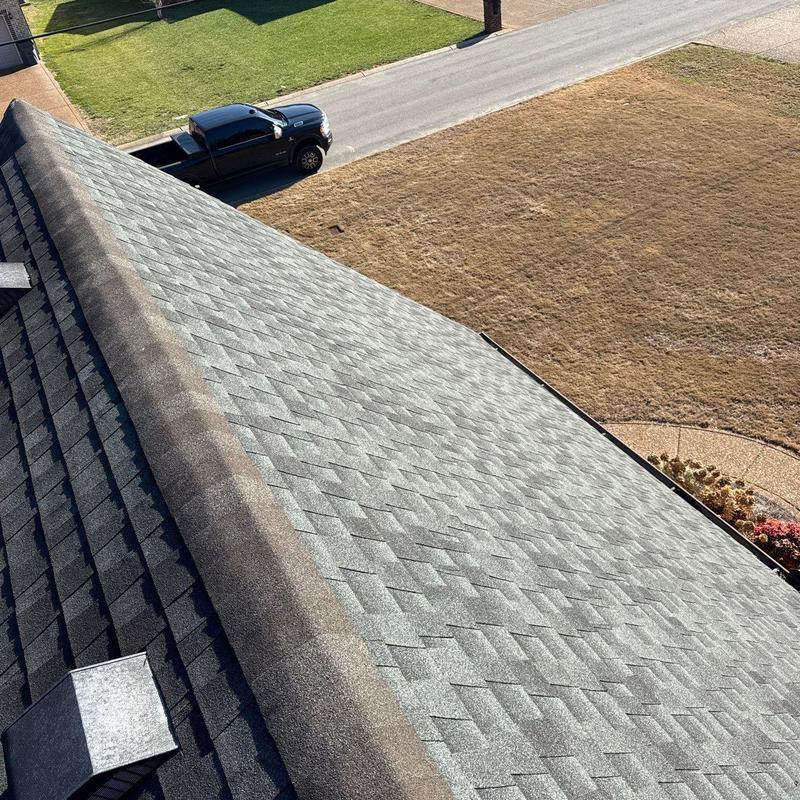 Asphalt shingle roof with damaged ridge cap and flashing