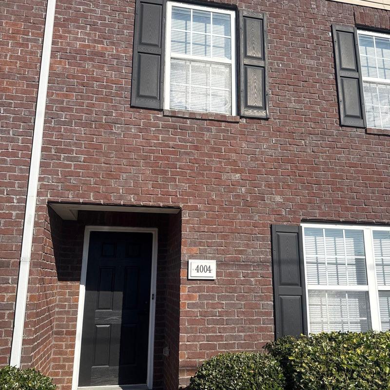 Brick exterior wall with windows and black door