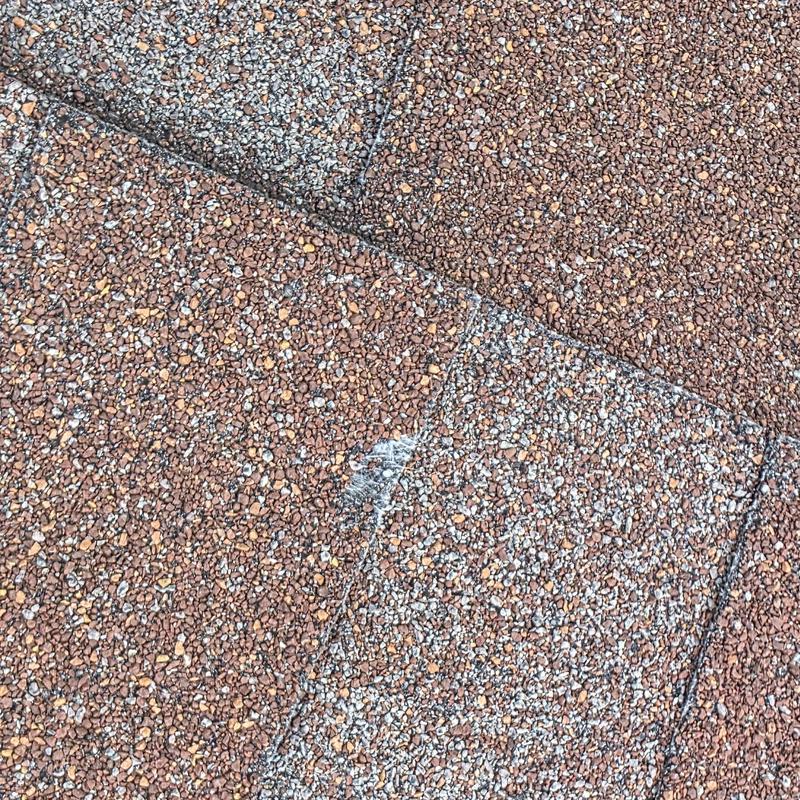 Asphalt roof shingles with hail damage on surface