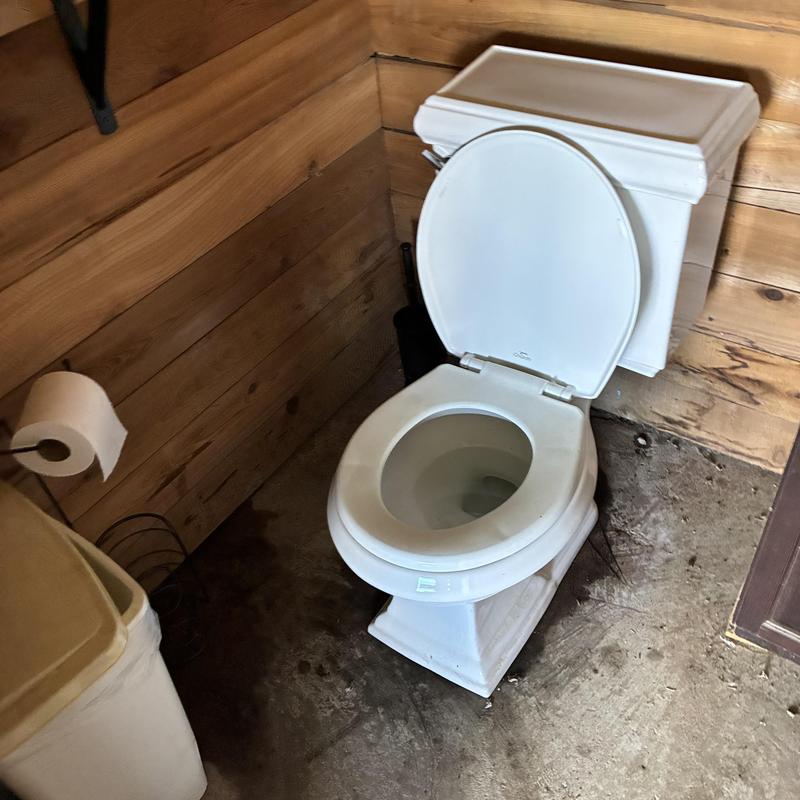Customer-supplied white toilet with open lid installed