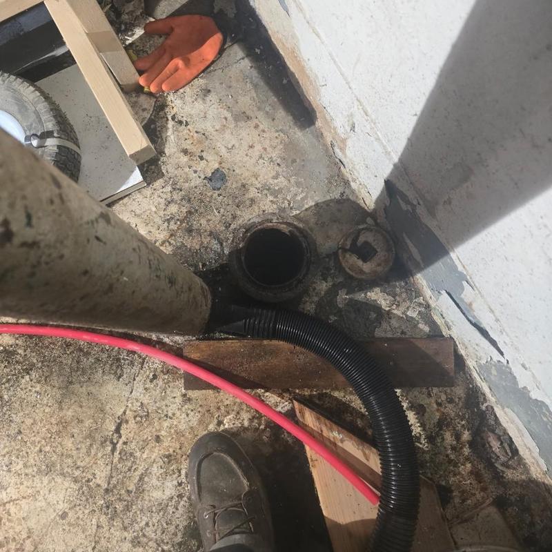 House trap plumbing pipe opening with tools nearby