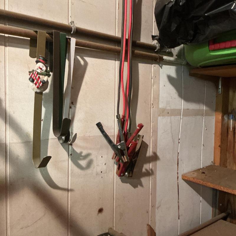 Drywall access hole cut below basement pipes and wires