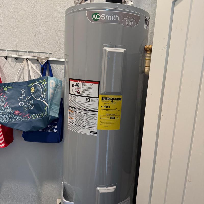Electric water heater installed in home utility closet