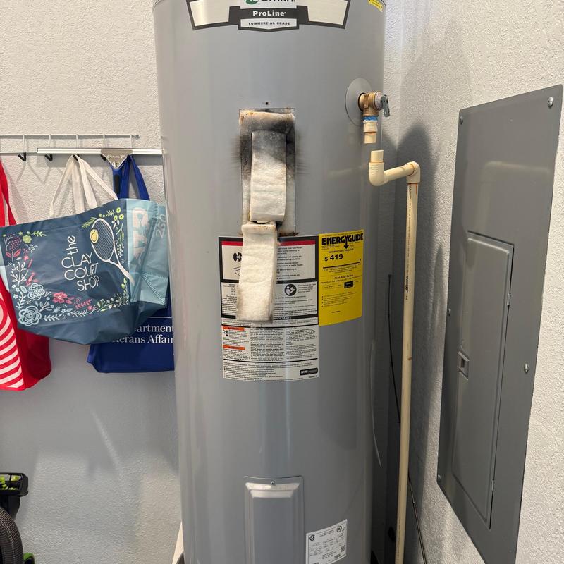 Electric water heater with burn marks on insulation panel