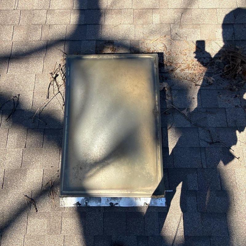Skylight unit on shingled roof with shadows