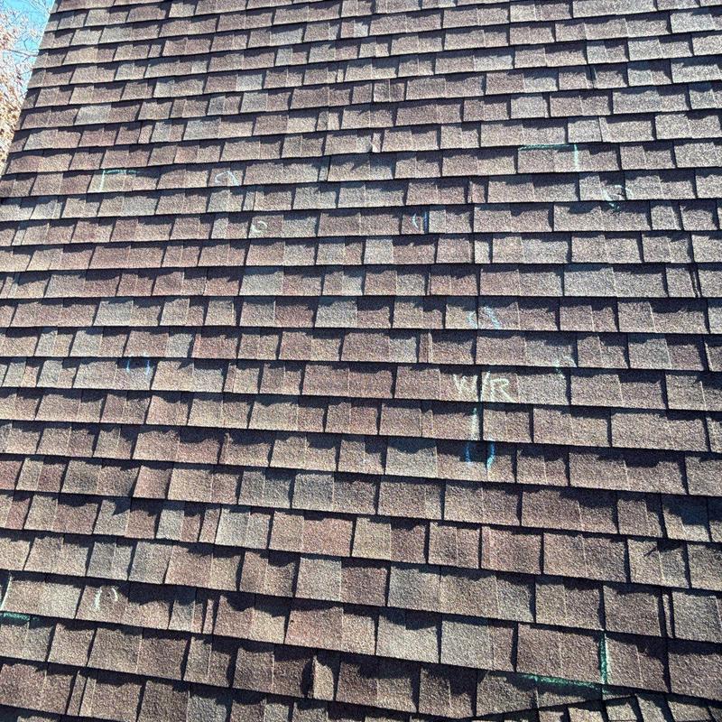 Asphalt roof shingles with marked hail damage