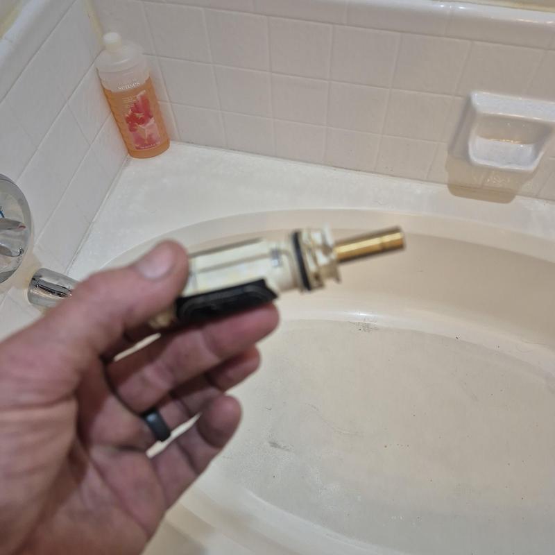 Moen posi-temp cartridge held over bathtub edge