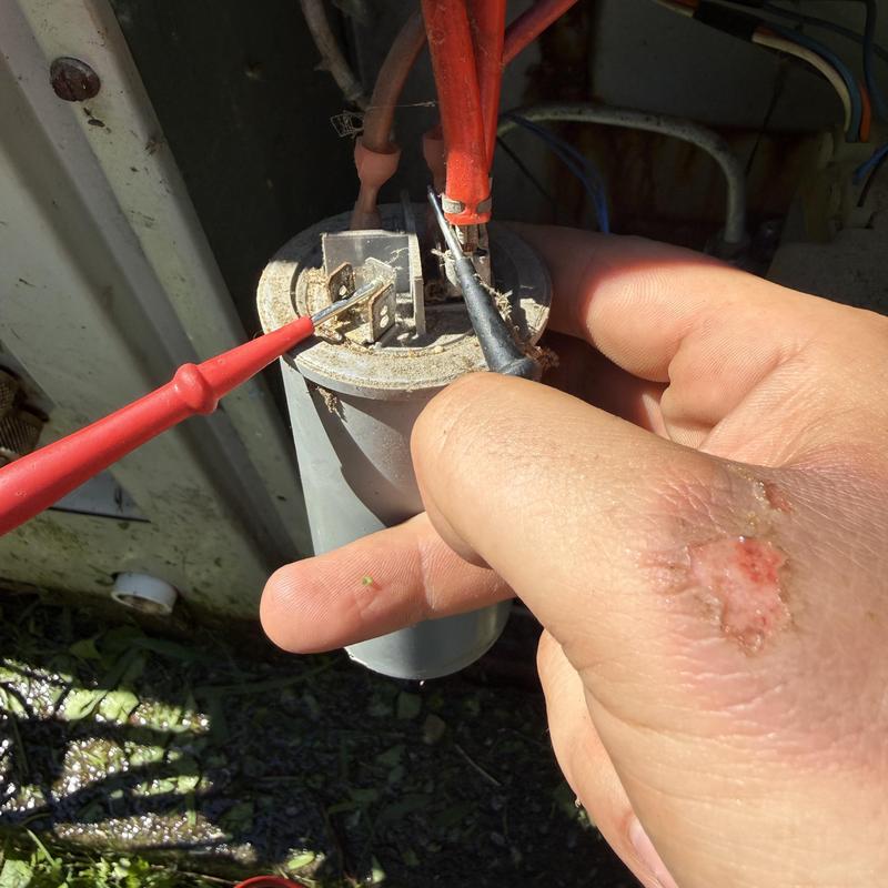 HVAC capacitor being tested with multimeter probes HVAC capacitor being tested with multimeter probes