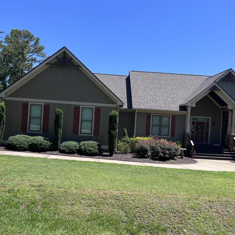 Asphalt shingle roof with wood beam accents and gutters