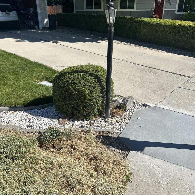 Yard light pole loose in ground by driveway edge