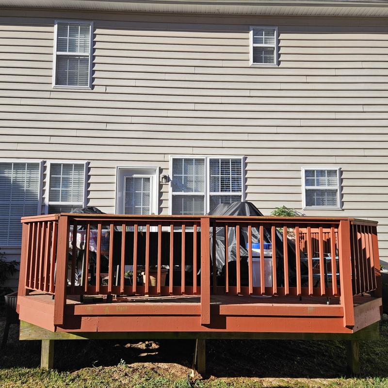 Wooden backyard deck with railing and outdoor furniture Wooden backyard deck with railing and outdoor furniture