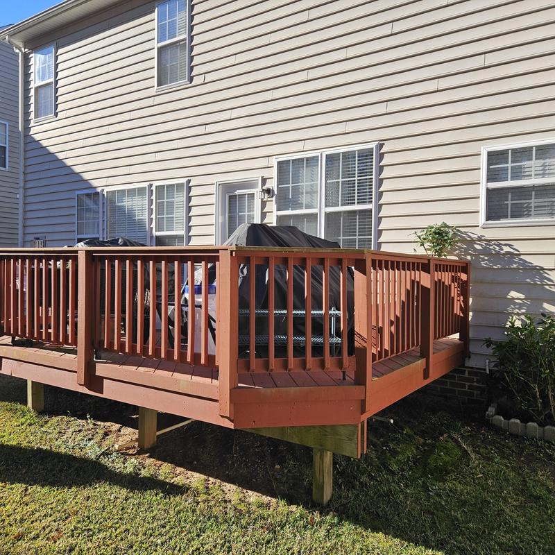 Wooden deck with railing attached to residential house Wooden deck with railing attached to residential house