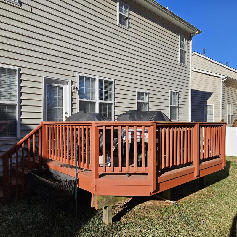 Wooden backyard deck with railing and stairs Wooden backyard deck with railing and stairs