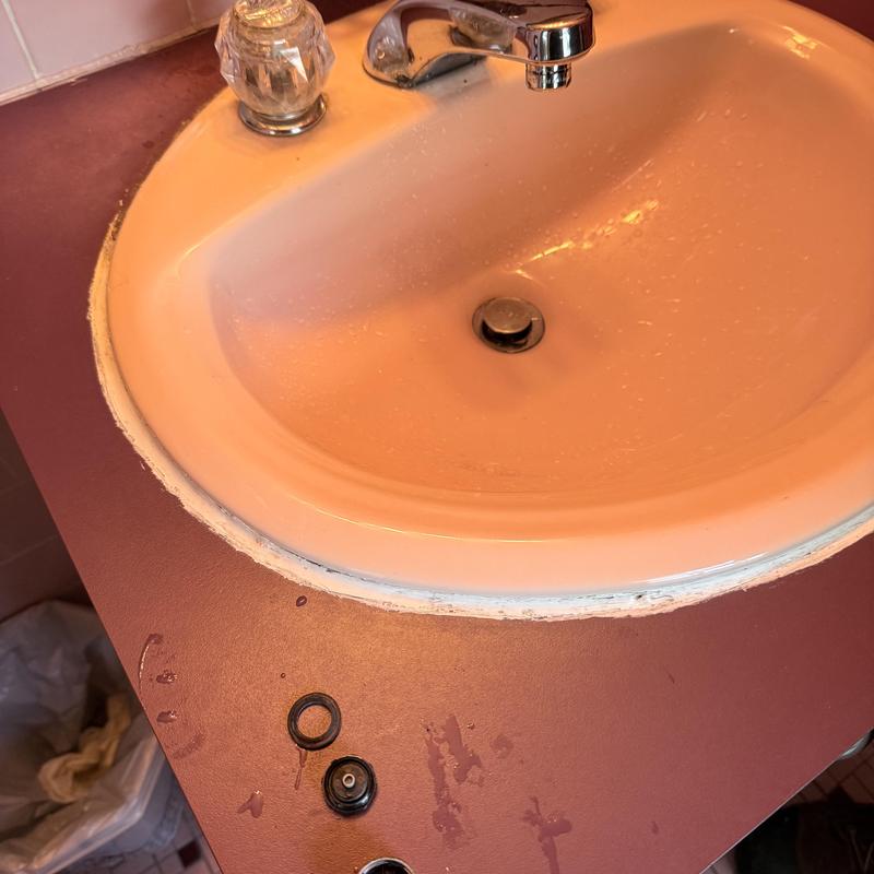 Bathroom sink faucet with disassembled parts on countertop Bathroom sink faucet with disassembled parts on countertop