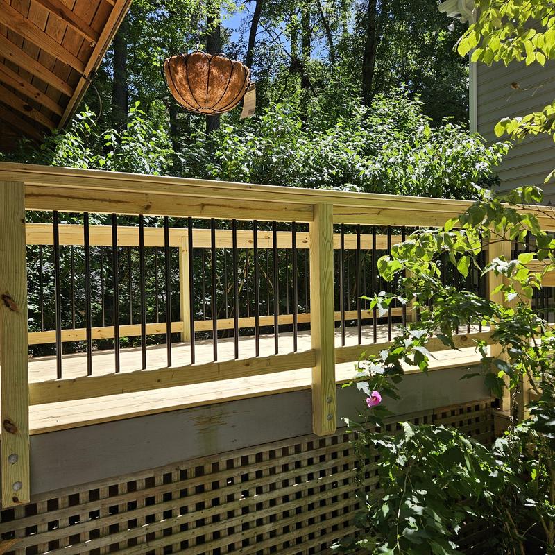 Wood deck railing with metal balusters in sunlight Wood deck railing with metal balusters in sunlight