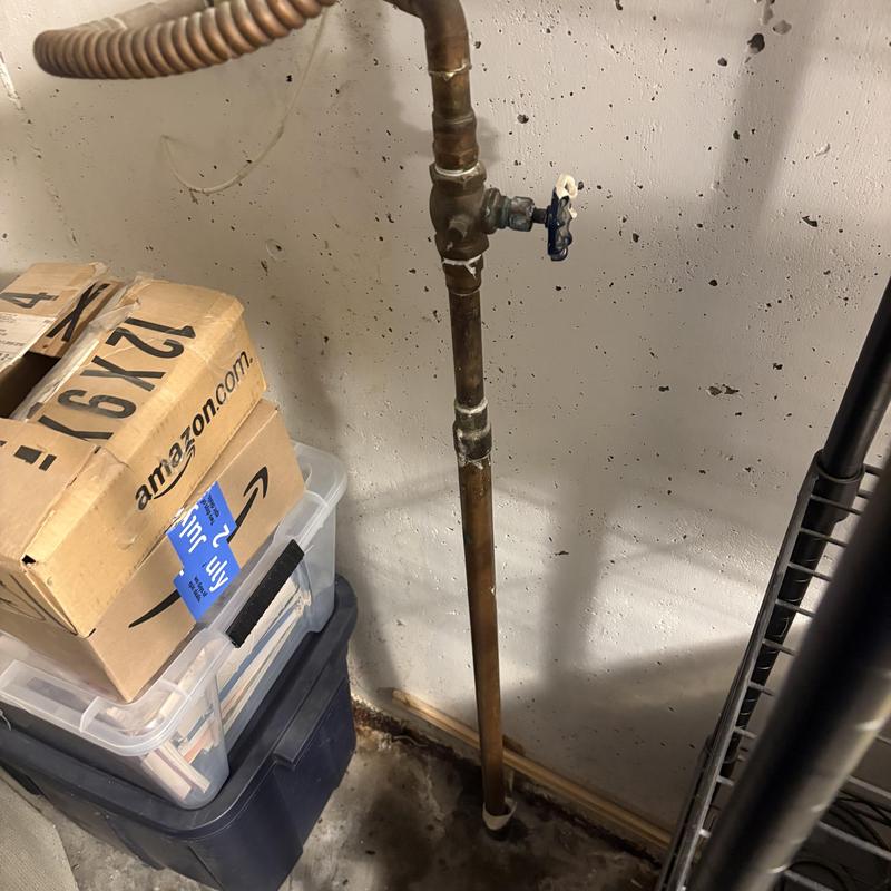 Copper water shutoff valve and pipe in basement wall