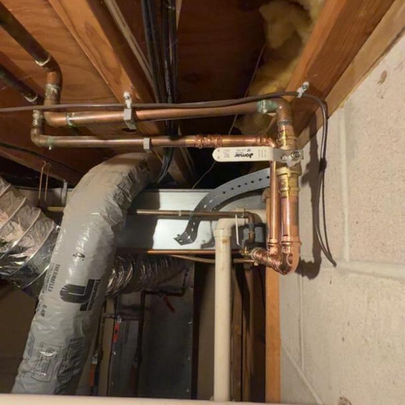 Copper water piping with valve in basement wall