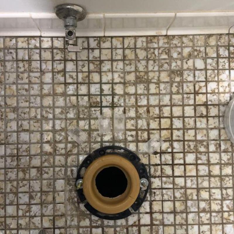 Toilet flange on tiled bathroom floor with water valve