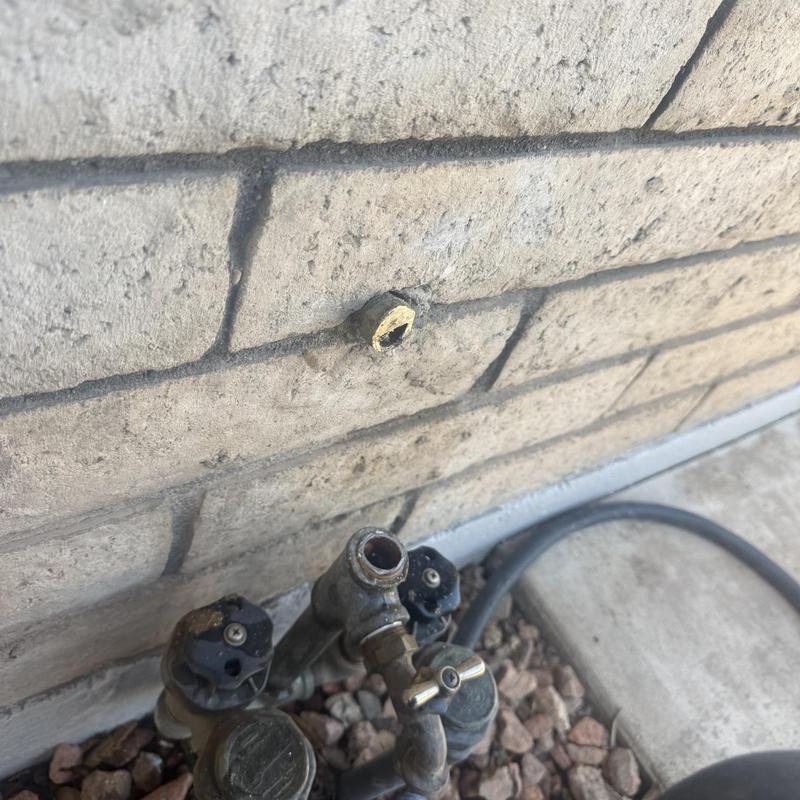 Outdoor hose bib water line extension work on brick wall