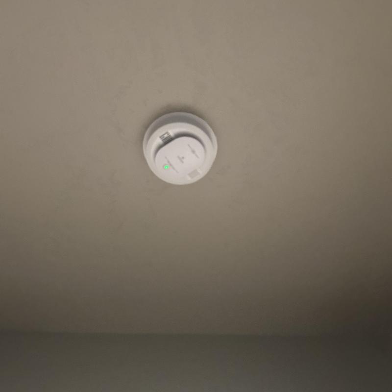 Hardwired smoke detector with battery backup on ceiling