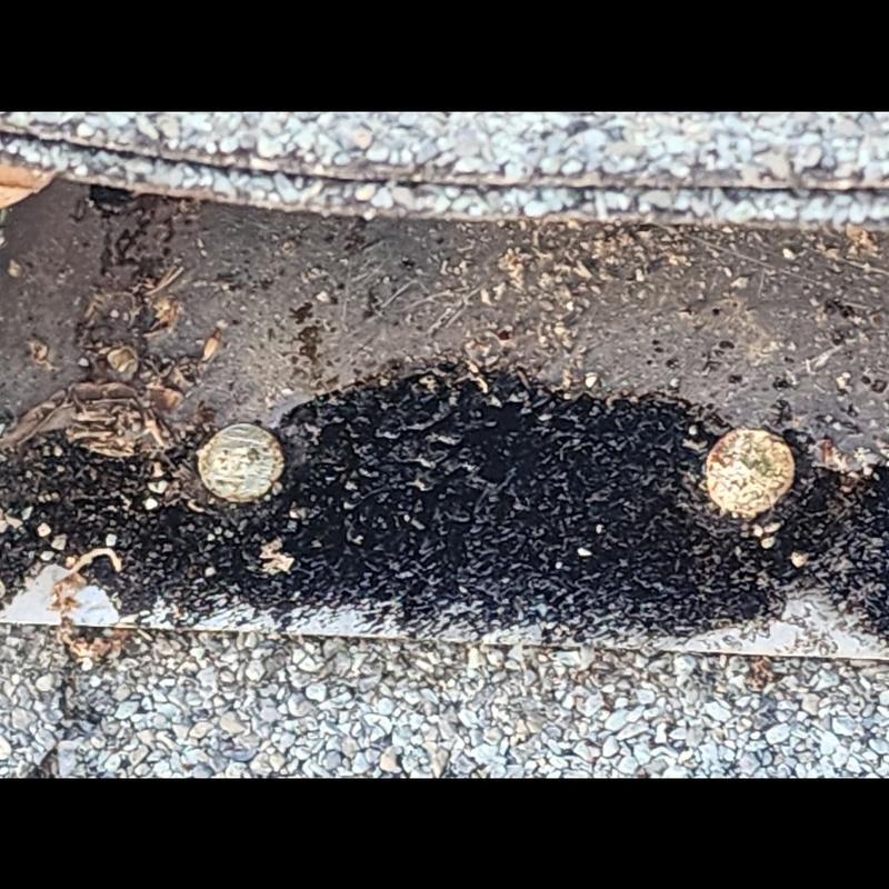 Roof shingle patch with nails and sealant close-up