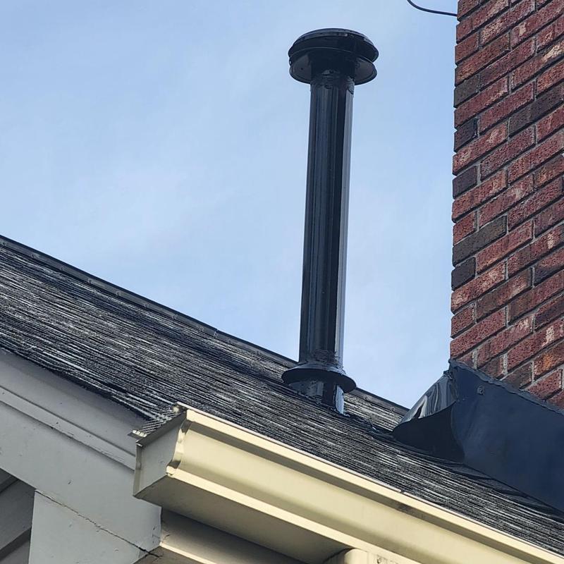 Heater pipe vent with rain collar on roof near chimney