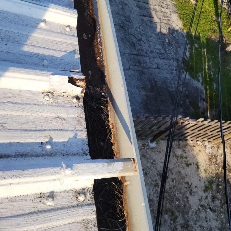 Metal building roof edge with rust and damage Metal building roof edge with rust and damage
