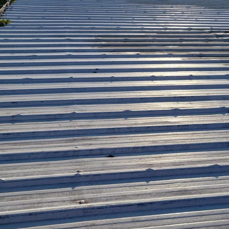Metal roof panels with aging repairs and loose fasteners Metal roof panels with aging repairs and loose fasteners