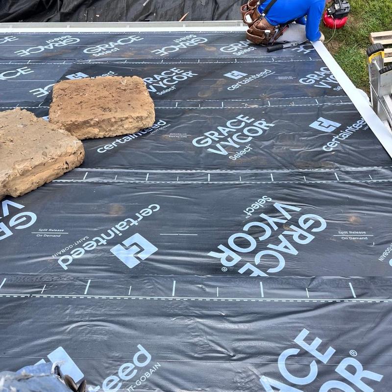 Roof underlayment installation with weighted stones Roof underlayment installation with weighted stones