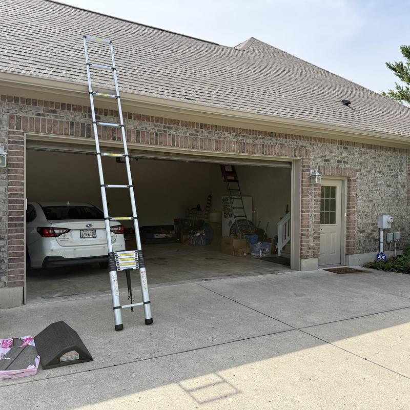 Asphalt shingle ridge cap with ladder by garage