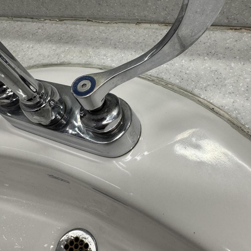 Commercial TNS faucet handle and sink basin close-up