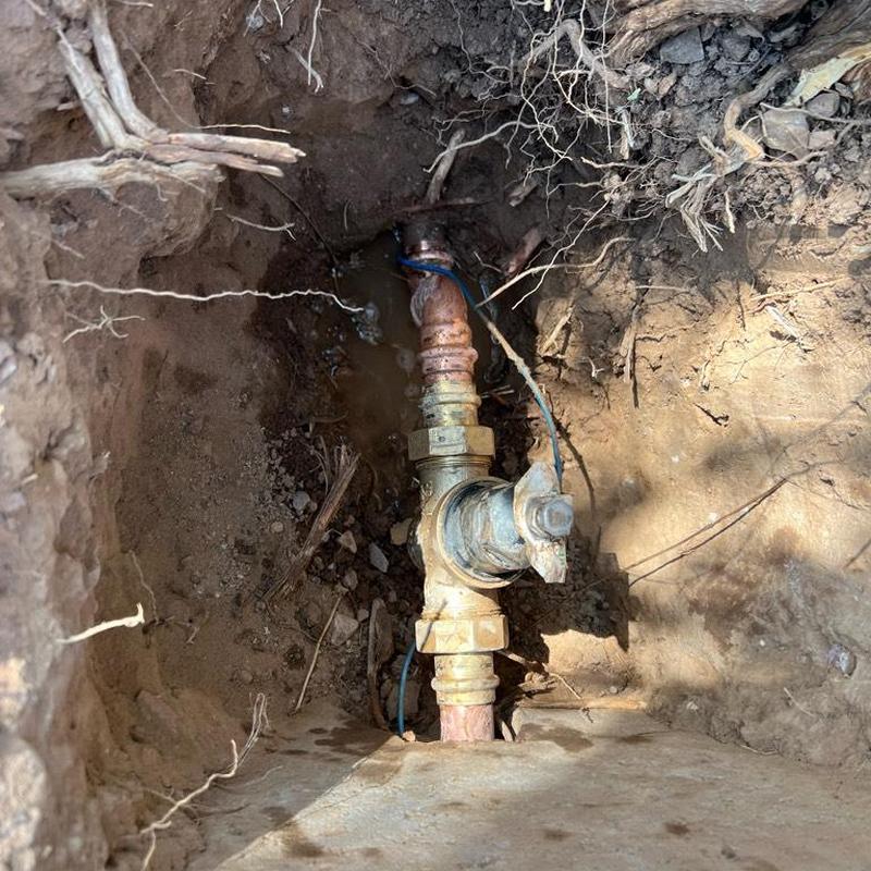 Water main valve installation in excavated soil pit