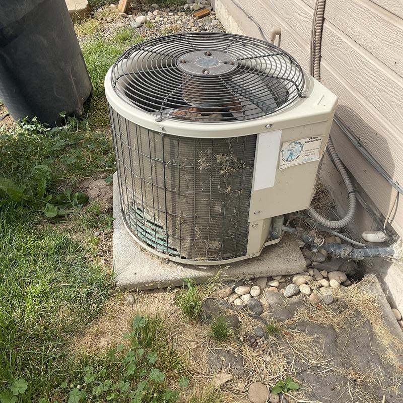Outdoor HVAC condenser unit with debris buildup